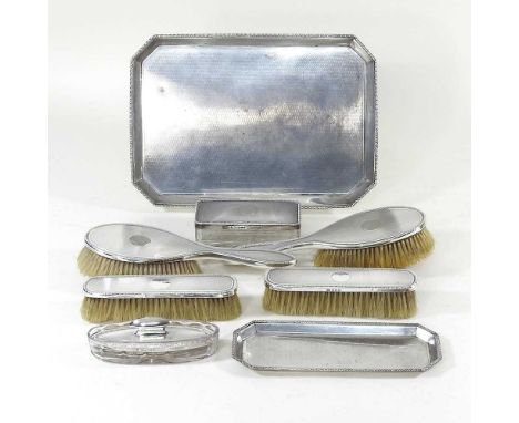 An early 20th century silver dressing table set, with engine turned decoration, comprising a tray, 436g, 30cm wide, two pairs