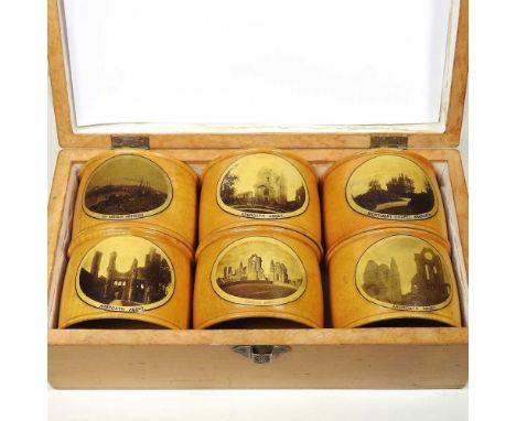 A 19th century Scottish sycamore Mauchlin ware napkin ring set, each transfer decorated with a view of Arbroath, in a wooden 