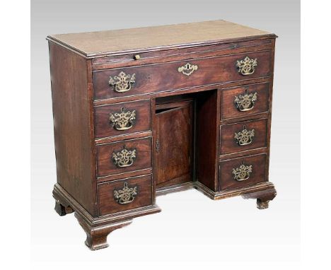 A George III and later mahogany kneehole desk, of small proportions, fitted with a slide, containing seven short drawers, abo