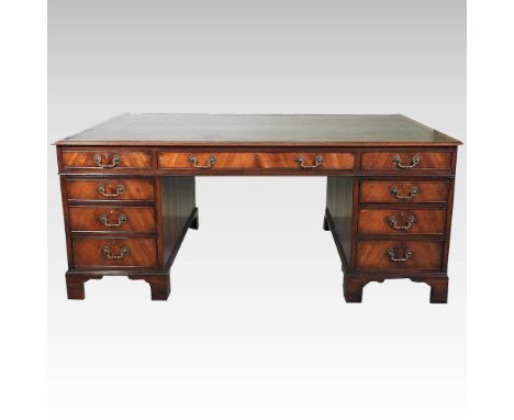 A large partners pedestal desk, 20th century, with an inset leather top, containing nine short drawers and opposing drawers a