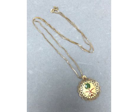 AN ENAMEL AND GOLD SAUDI ARABIA PENDANT SUSPENDED ON A 60cm BOX CHAIN. THE PENDANT AND CHAIN STAMPED 750, BOTH ASSESSED AS 18