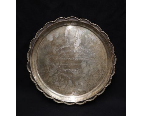 A George V silver waiter of circular form with a shaped edge on three paw feet, the plate engraved "Newport Athletic Club Bad