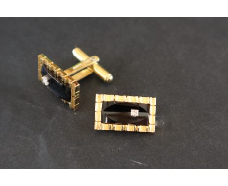 A pair of 14ct yellow gold cufflinks of rectangular form set with a rectangular onyx panel and a round brilliant cut diamond,