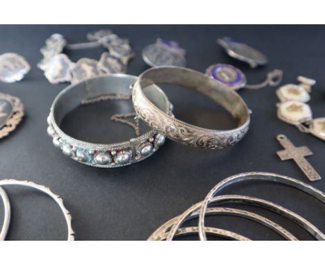 A silver bangle together with other silver and white metal bangles, Siamese bracelet and brooch, a Chinese silver and mother 