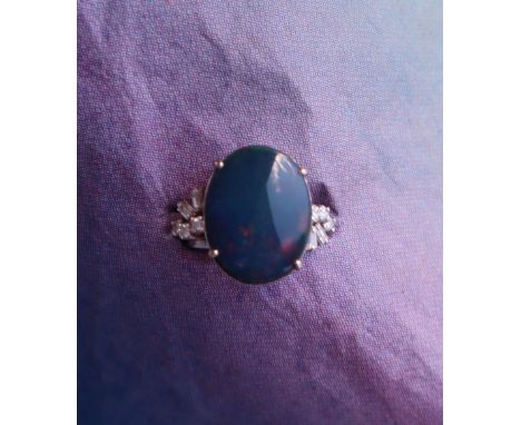 A black opal and diamond ring, the opal approximately 16mm x 12mm, the shoulders set with baguette and brilliant cut diamonds