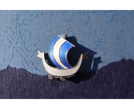 A Norwegian silver and enamel viking ship brooch with blue and white enamel for Aksel Holmsen