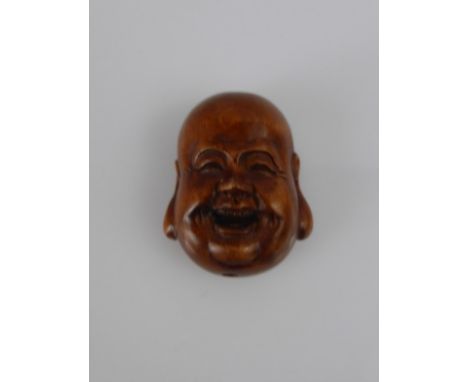A Japanese Netsuke, in the form of a jolly face, with character marks to base.