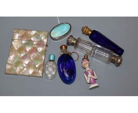 A 1930's silver and enamel pill box, four assorted mounted glass scent bottles including enamel, a porcelain 'lady' scent bot