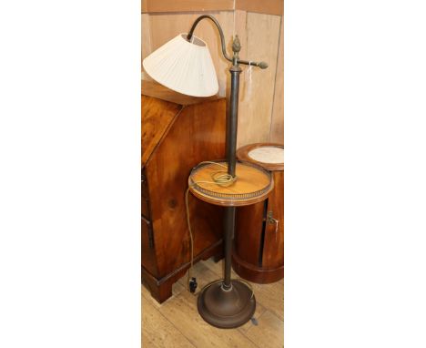 An Edwardian tubular brass adjustable standard lamp with mahogany tier
