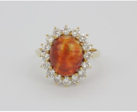 An 18ct yellow gold cluster ring set with a large cabochon cut opal, approx. 1ct diamonds overall, (L).