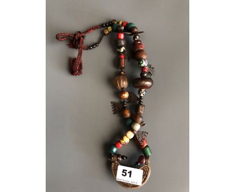 A Tibetan re-strung pilgrim's necklace of sacred glass, bone, ceramic, stone and bronze objects collected during one or more 