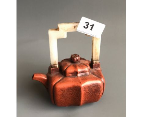 A Chinese Yixing terracotta teapot with carved white jade handle. H. 12.5cms. Condition good with no visible damage or repair