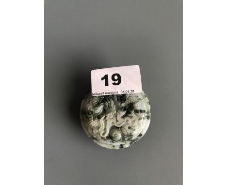 A Chinese carved spinach jade dragon buckle. D. 6cms. Condition excellent.