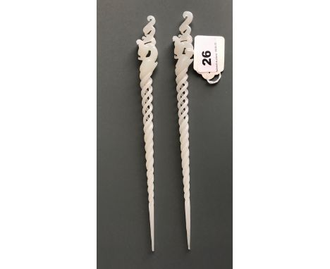 A superb pair of intricately carved Chinese white jade hair ornaments topped with stylised dragon heads, implying members of 