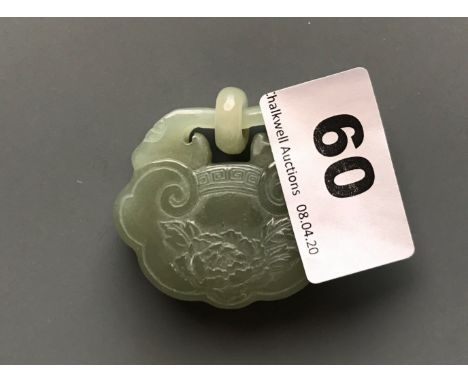 A carved green nephrite jade lock amulet with integral ring and decorated with a flower, usually given as a lover's token. W.