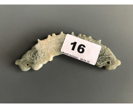 A Chinese archaic form carved mixed colour nephrite jade amulet. W. 11cms. Condition good with no visible damage or repair.