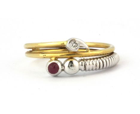 An 18ct yellow and white gold diamond and ruby set crossover ring, (N).
