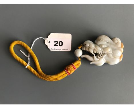A superb 19th/ early 20thC Sino-Tibetan carved mutton fat and russet jadeite jade dragon head amulet and bead on a Tibetan si