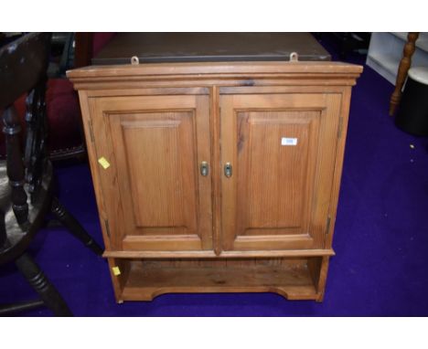 A pine wall cabinet with shelf under