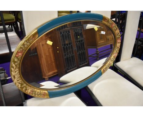 A vintage painted oval wall mirror
