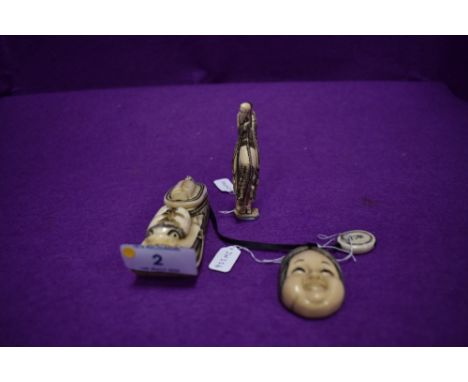 Two late 19th early 20th century signed carved ivory netsuke one of a god riding a horse and the other a mask of a woman A ca