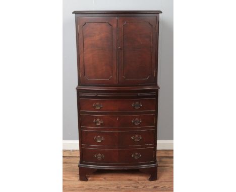 A bow fronted mahogany drinks cabinet, with cupboard doors, pull-out shelf and fake drawers to the base. Height: 131cm.  