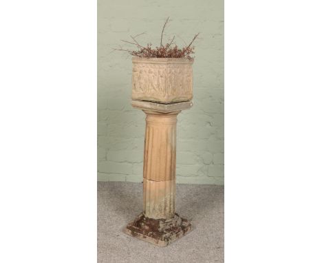 A Corinthian style garden pillar, with square foot and base, with a small cube garden planter depicting cherubs. Height of pi