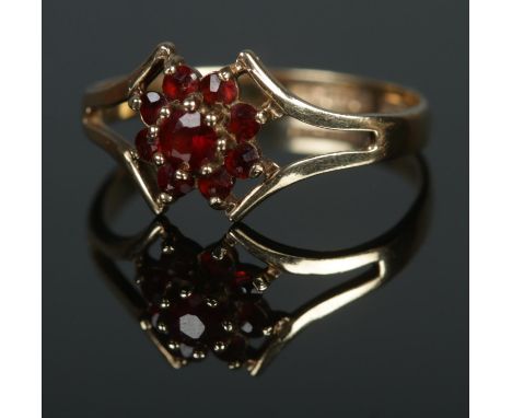 A 9ct gold cluster ring set with nine garnets. Size M, 1.48g.  