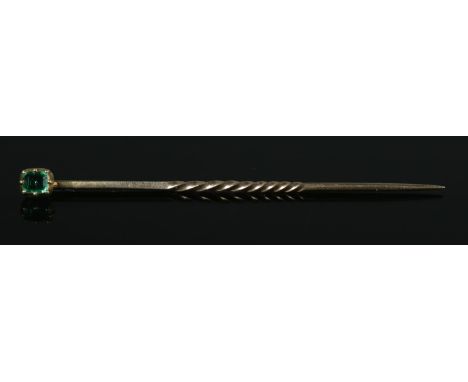 A Gold and Emerald stick pin, with part twisted stem. 47mm long. Size of stone 3mm. Total weight: 0.6g. Tested.  Some very sm