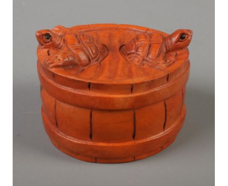 A Japanese carved Netsuke in the form of two turtles in a barrel .  