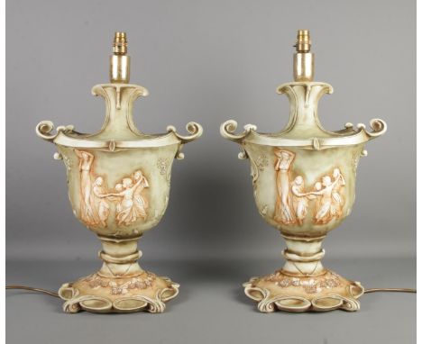 A large pair of Florence ceramic table lamps, formed as twin handled urns with figures to the front, on squared base. Height:
