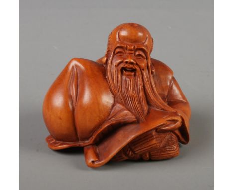 A Japanese carved Netsuke in the form of the god of longevity, signed to base.  