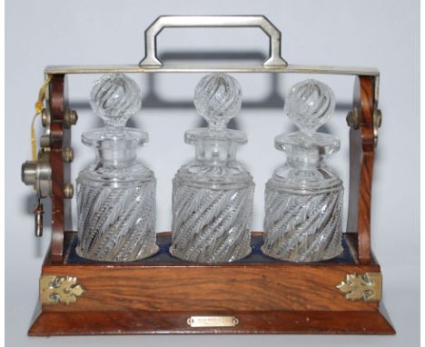 A miniature Betjemann's Tantalus, patent no. 14659, c1880 with key and lock together with three crystal Decanters with spiral