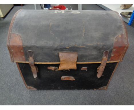 An antique canvas and leather dome-topped shipping trunk. 
