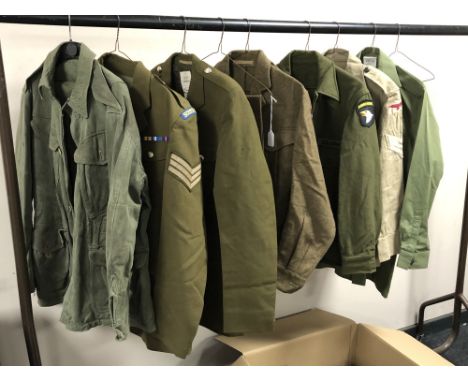 A rail of Second World War and later military uniforms comprising combat smock, British Sergeant's tunic marked Scot's Guards