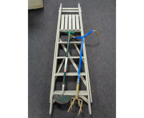 A set of folding wooden garden steps together with two garden tools 