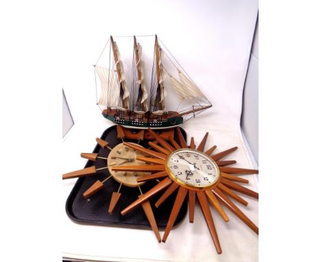 A tray of two teak sunburst wall clocks together with a model of a galleon 
