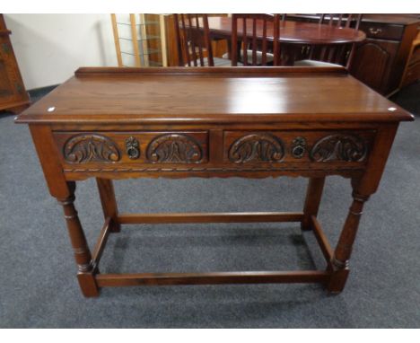 A carved oak Old Charm two drawer console table. 