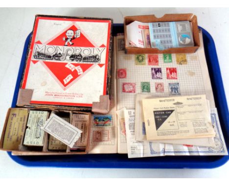 A tray of vintage monopoly set, train ticket stubs, two stamp albums with partial contents 