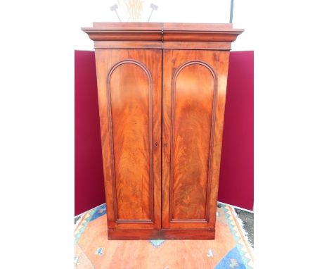 Victorian mahogany wardrobe, with moulded cornice enclosed by a pair of arch moulded panel doors, on plinth base. (W122cm x D