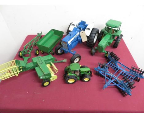 Large scale Ertl diecast model of a blue Ford 8600 tractor harrow, a smaller Ertl green tractor with bailer, plough and trail