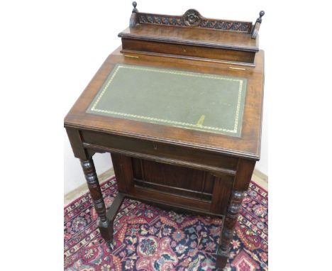 Victorian mahogany davenport with raised lift up top section with carved detail, revealing fitted interior above slope front 