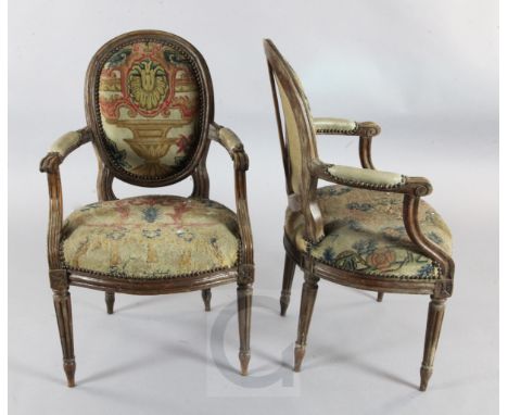 A set of six Louis XVI style stained beech fauteuils, with foliate tapestry woven upholstery, part padded scrolled arms on tu