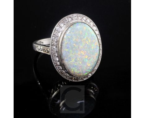 An 18ct gold and platinum, white opal and diamond set oval dress ring, with diamond set shoulders, the stone measuring approx