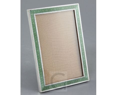 An early 20th century continental silver and two colour enamel mounted rectangular photograph frame, the green enamelled bord