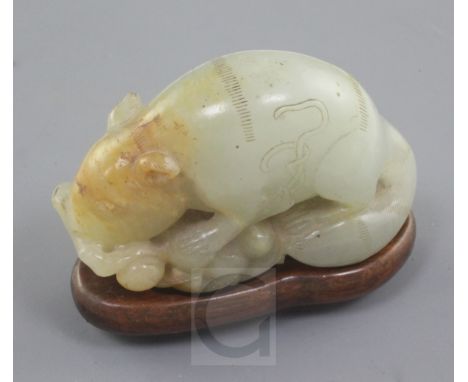 A Chinese pale celadon and russet jade figure of a tree shrew or squirrel, 18th / 19th century, eating and clambering on a fr