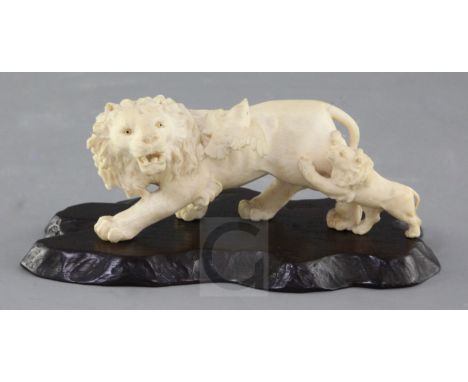 A Japanese ivory okimono of a lion and cub, early 20th century, the lion with glass inset eyes, the cub looking towards a bir