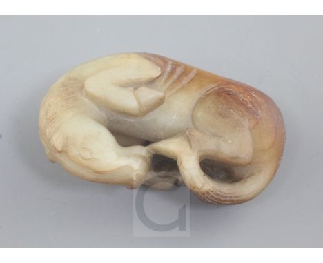 A Chinese yellow and russet jade figure of a recumbent horse, 8.5cm