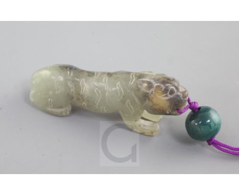 A Chinese celadon and black jade figure of a crouching tiger, Song dynasty style and possibly of the period, length 4.5cm