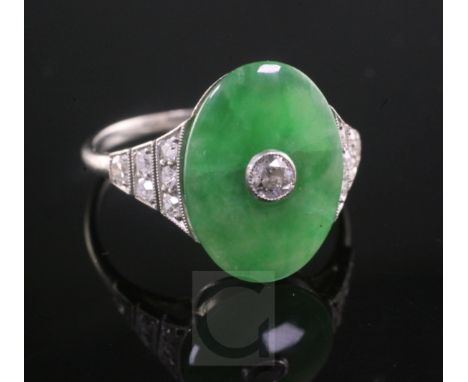 A 1920's style platinum, jadeite and diamond ring dress ring, the oval cut jade with central diamond and diamond set shoulder